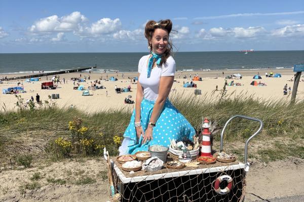 Foto van Madame Océan die op de dijk staat van Oostende voor het strand. 