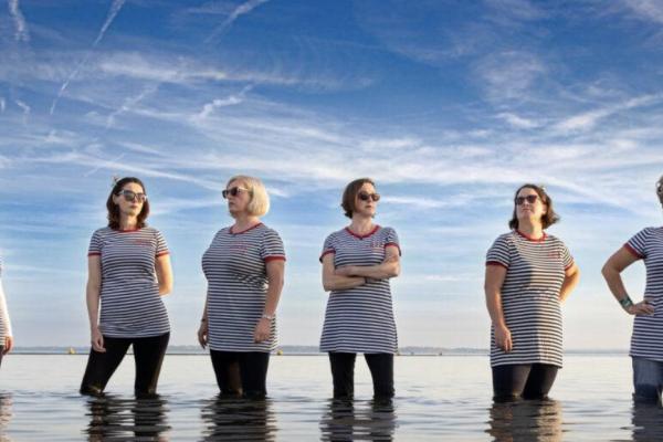 Foto van The Silver Darlings die in de zee staan. 